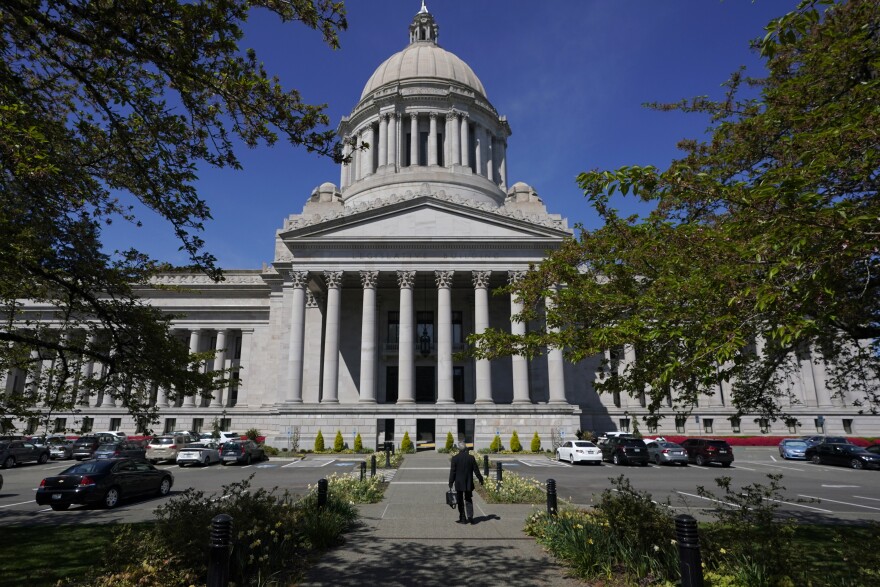 A person walks near the Legislative Building, Wednesday, April 21, 2021, at the Capitol in Olympia, Washington.