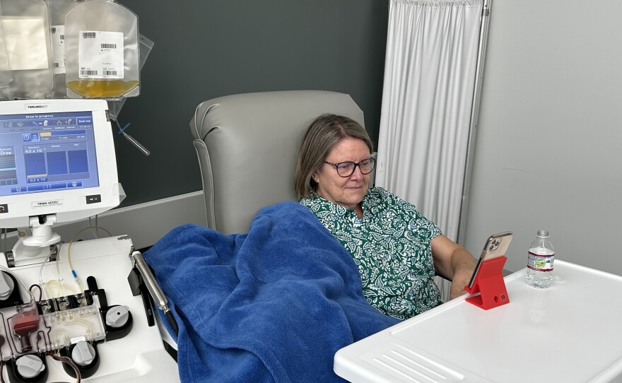 Donor, Jackie McCoy, watches videos on her phone as she donates platelets.
