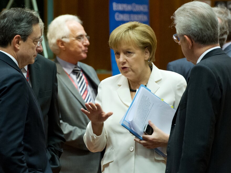 German Chancellor Angela Merkel talks with European Central Bank President Mario Draghi (left) and Italian Prime Minister Mario Monti (right) during a summit of European leaders in Brussels. They reached an agreement on a growth plan for the continent, and world markets surged.