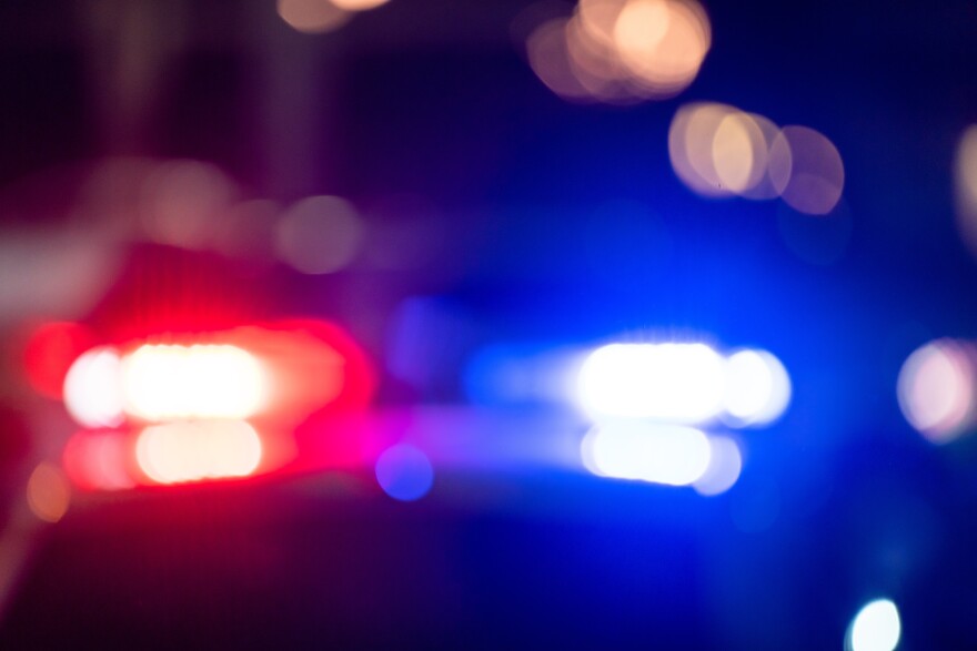 blurred photo of police car with red and blue lights at night