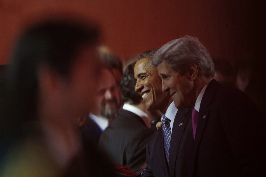 President Obama (center) and Secretary of State John Kerry (right) attend Monday's opening ceremony of the United Nations Climate Change Conference in the Paris suburb of Le Bourget.