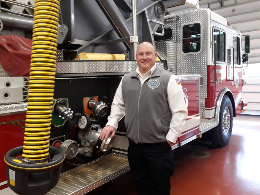 Ellwood City Fire Chief Rick Myers stands in front of a fire truck in the station's garage. 