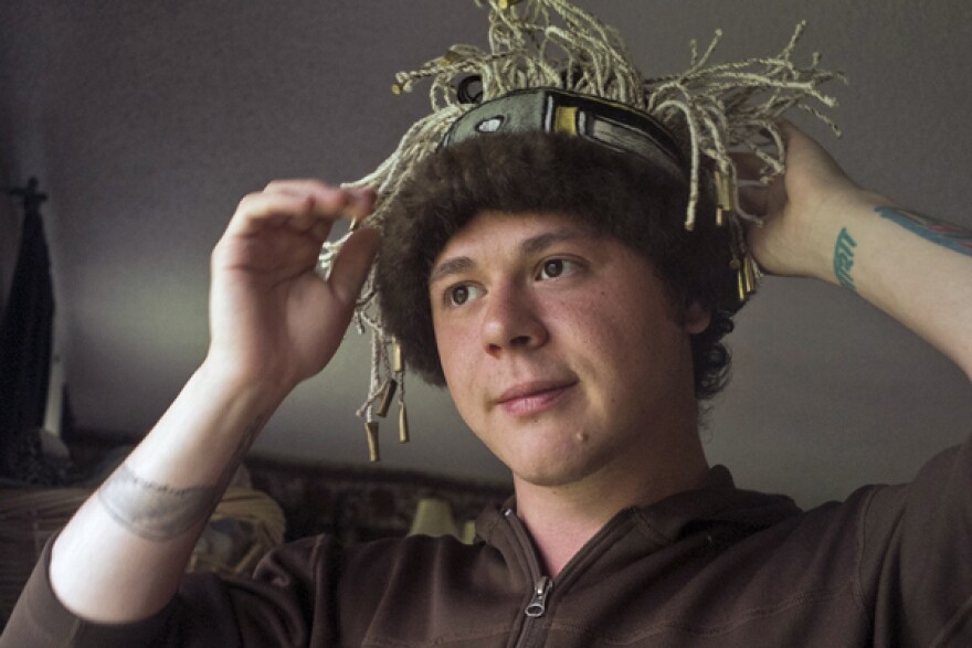 Ricky Tagaban models one of his headbands in his living room. (Photo by Annie Bartholomew, KTOO - Juneau)