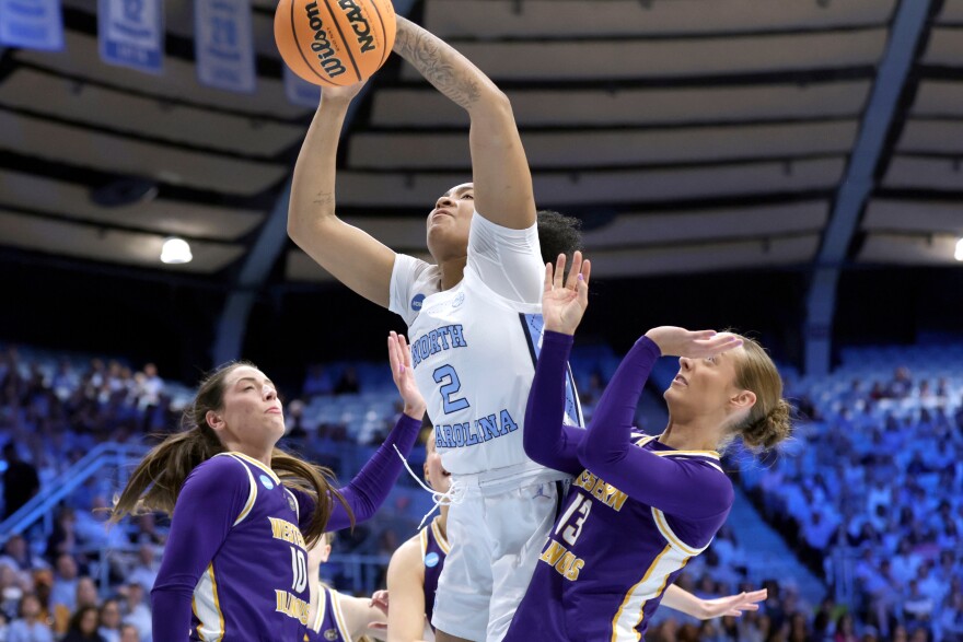 North Carolina forward Nyla Harris (2) drives against Western Illinois forward Mallory Shetley (10) and guard Addi Brownfield (13) during the first half in the first round of the NCAA college basketball tournament Friday, March 20, 2026, in Chapel Hill, N.C.