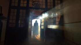 A Chateau Le Fear cast member waits for thrill seekers at the house of horror show in Londonderry, Northern Ireland.