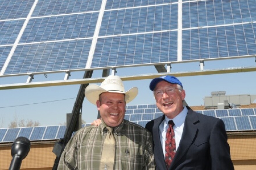 Andy Swapp (left) with Secretary Ken Salazar in front of a newly installed solar panel at Milford High School.