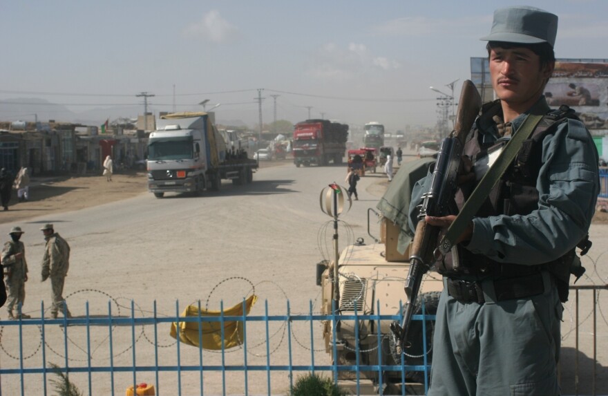An Afghan police officer stands guard near the site where a suicide bomb attack took the life of five Americans, including 25-year-old Foreign Service officer Anne Smedinghoff, in Afghanistan on Saturday.
