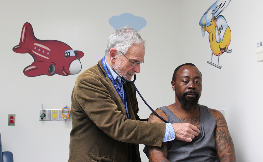 Dr. Elliott Vichinsky examines Derek Perkins at the sickle cell center at UCSF Benioff Children's Hospital Oakland, where both adults and children with sickle cell disease receive care.