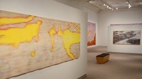 Colorful art hangs on walls inside a gallery