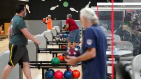 People separated by plexiglass barriers bowl at Homefield Bowl in Yonkers, N.Y., in August.
