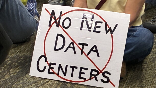 An opponent of data centers in the Roanoke Valley holds a sign during a meeting of the Western Virginia Regional Industrial Facility Authority.