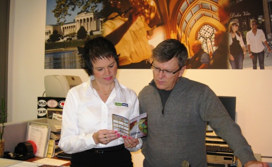 Denise Drews, Visitor Center Manager at Visit Buffalo Niagara & Edward J. Healy. Vice President of Marketing review a brochure