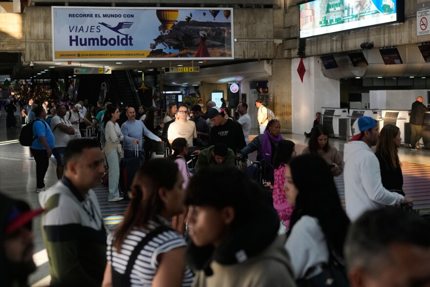 Passengers line up to check in for international flights at an airport terminal.