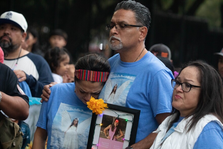 Family members of Jacklyn Jaylen Cazares hold a photo of her during Tuesday's vigil.