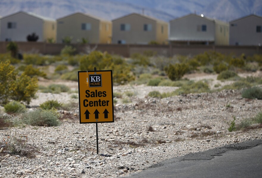 In this April 13, 2015, photo, a sign points the way to a sales center for tract housing in Las Vegas.