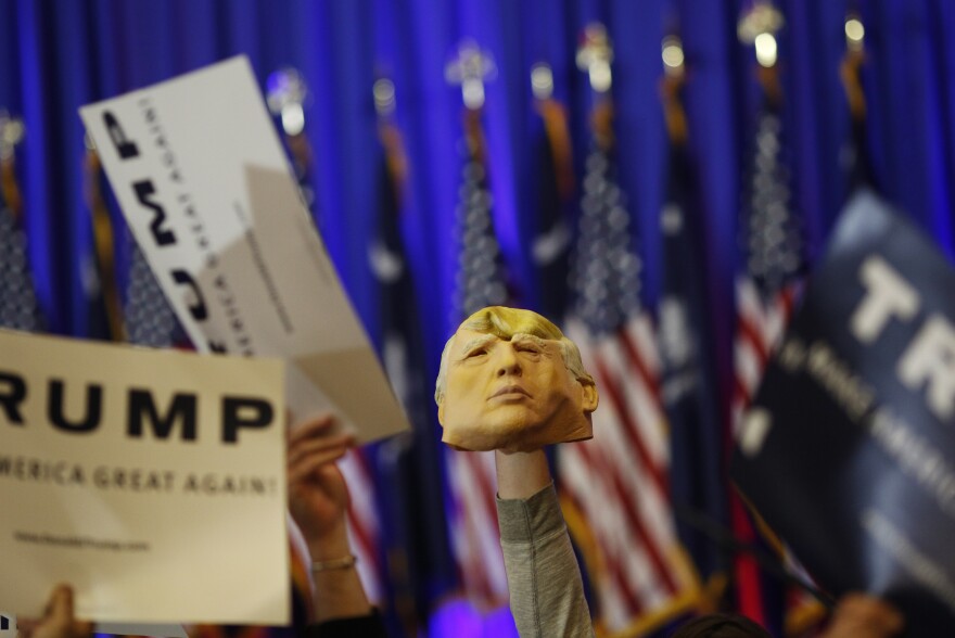 An attendee holds a mask of Donald Trump during a rally in Spartanburg, S.C. Trump won Saturday's South Carolina primary, further entrenching his status as front-runner for the GOP nomination.