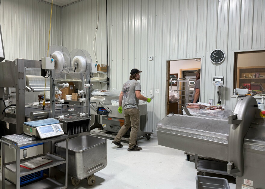 Ryan Freman is speaking to Trey Freman in their processing facility. There are several different processing machines arond.
