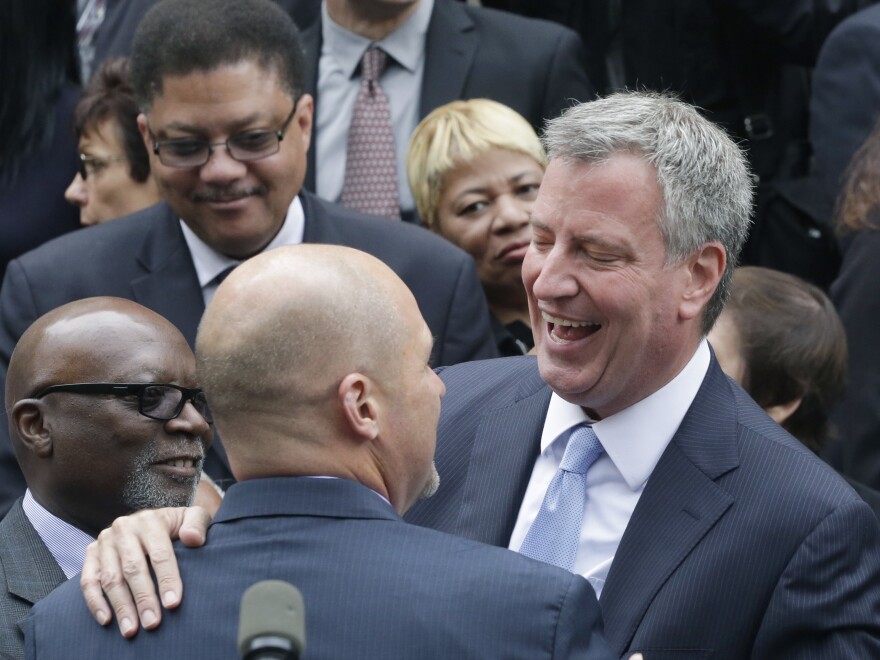 Democrat Bill de Blasio embraces a supporter on the steps of City Hall on Monday.