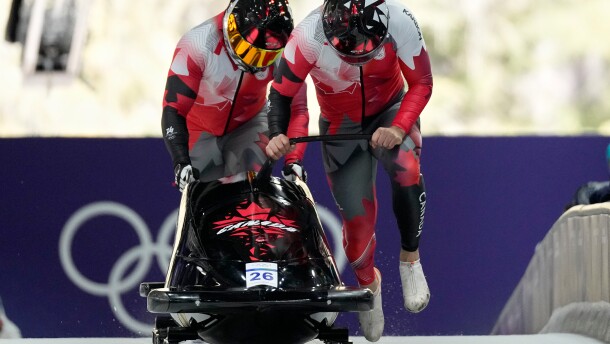 Canada's Taylor Austin, right, and Shaquille Murray-Lawrence start for a two man bobsled run at the 2026 Winter Olympics, in Cortina d'Ampezzo, Italy, Monday, Feb. 16, 2026. (AP Photo/Alessandra Tarantino)