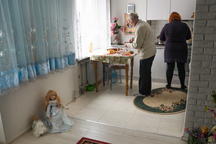 Viktor Lada and Svitlana Domoratska, a social worker, in the kitchen of the Ladas' new apartment. The Ladas were able to bring a few items from their old home, but many were damaged in the strike.