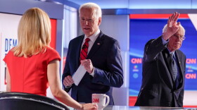 Former Vice President Joe Biden, center, stops to talk with CNN anchor Dana Bash, left, as Sen. Bernie Sanders, I-Vt., right, waves after they participated in a Democratic presidential primary debate on March 15.