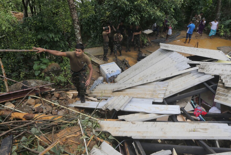 A Sri Lankan army soldier walks on the debris of a house during a search operation in Elangapitiya village in Aranayake, some 45 miles north of Colombo, Sri Lanka, on Thursday.