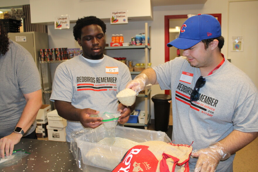 Two student volunteers scoop rice into portion bags at the School Street Food Pantry.