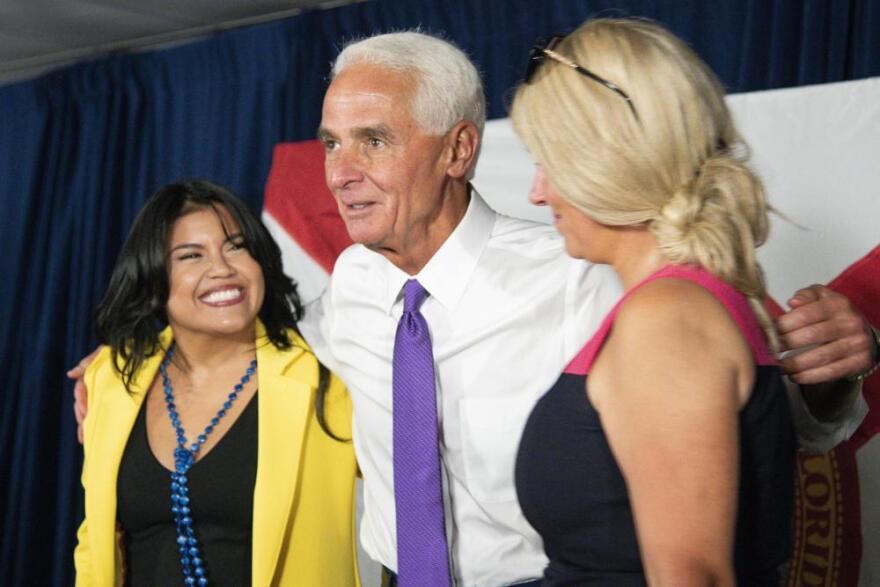 U.S. Rep. Charlie Crist, center, and his fiancé Chelsea Grimes, right, celebrate as he announces his running mate Karla Hernández-Mats, left, at Hialeah Middle School in Hialeah, Fla., Saturday Aug. 27, 2022.Crist will face incumbent Republican Gov. Ron DeSantis in November.