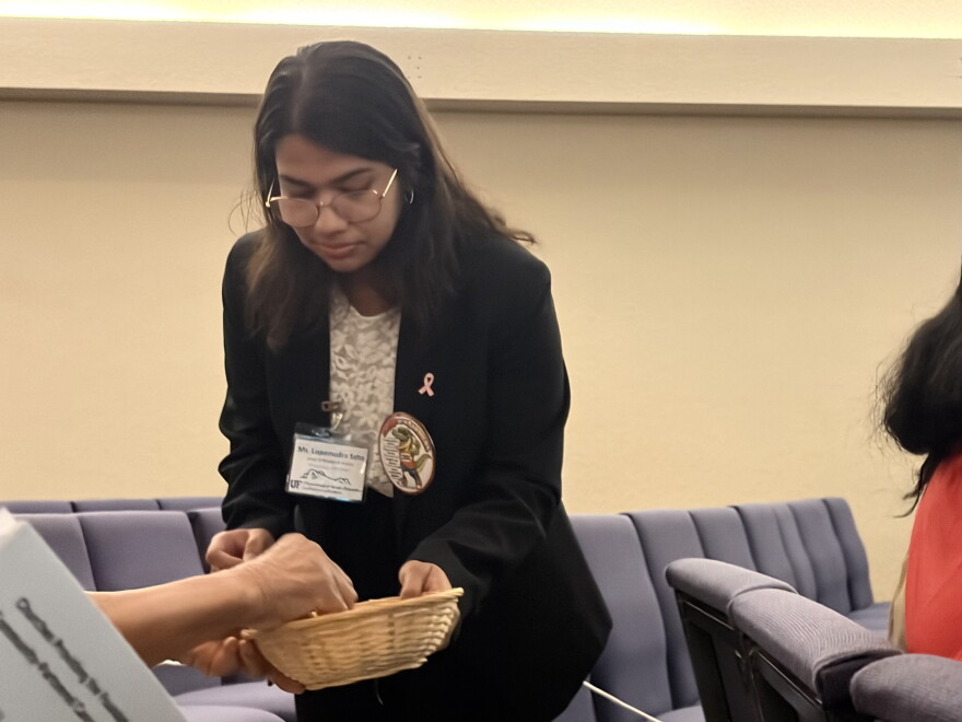 A health intern collects audience questions for U.S. Rep. Kat Cammack during the cancer disparities research showcase on Thursday, Oct. 22, 2026. (Emilia Hueller/WUFT News)