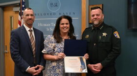 FBI Charlotte Special Agent in Charge Robert M. DeWitt and Pasquotank County Sheriff Tommy S. Wooten II present Tina Pennington with the certificate for the DCLA award.