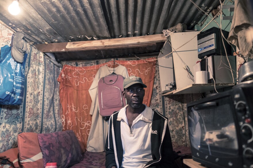 Ishmae Uchani, 47, in his one-room home in the township of Masiphumelele in Cape Town. Uchani shares his house, which measures approximately 6 feet by 10 feet, with his wife and two children. He says the government's orders to stay at home during the coronavirus lockdown are unworkable. Uchani was a day laborer in the construction industry before the lockdown and has now lost his income.