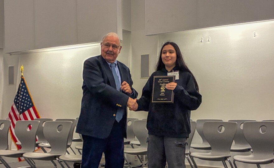Yuma County School Superintendent Tom Hurt presents Smriti Parajuli with a plaque commemorating her win.