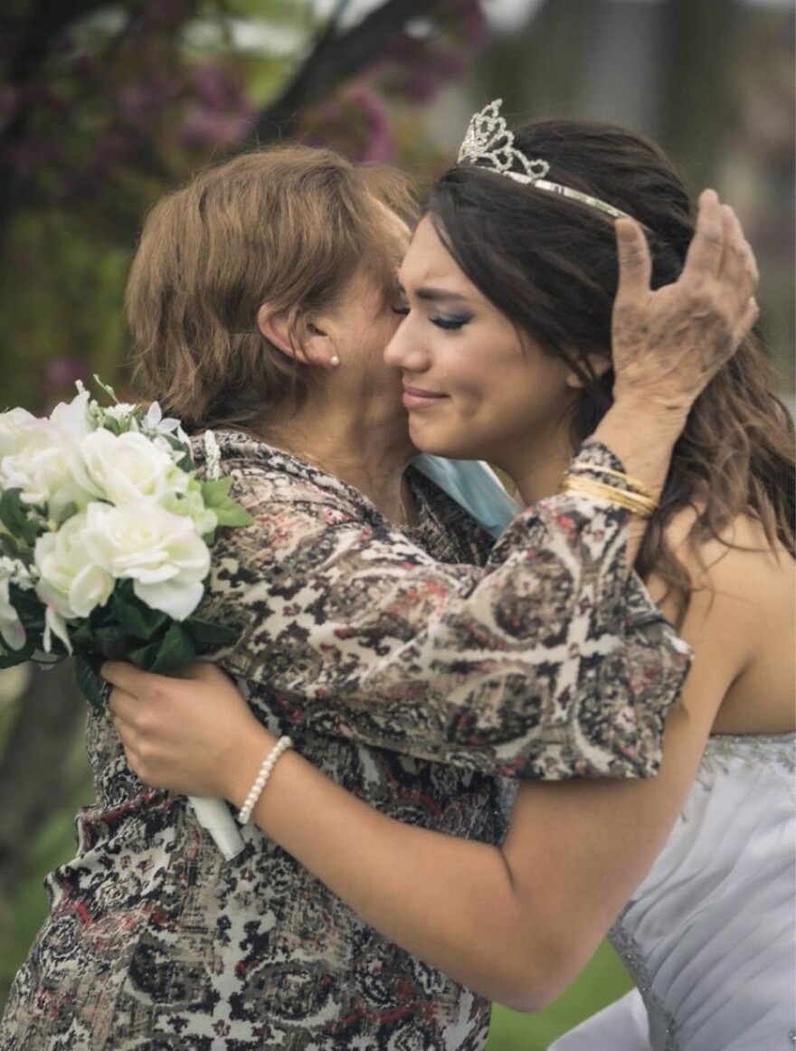 Marlena Modica cries as she hugs her grandmother for the first time in months on the day of her quinceañera celebration, May 13, 2020.