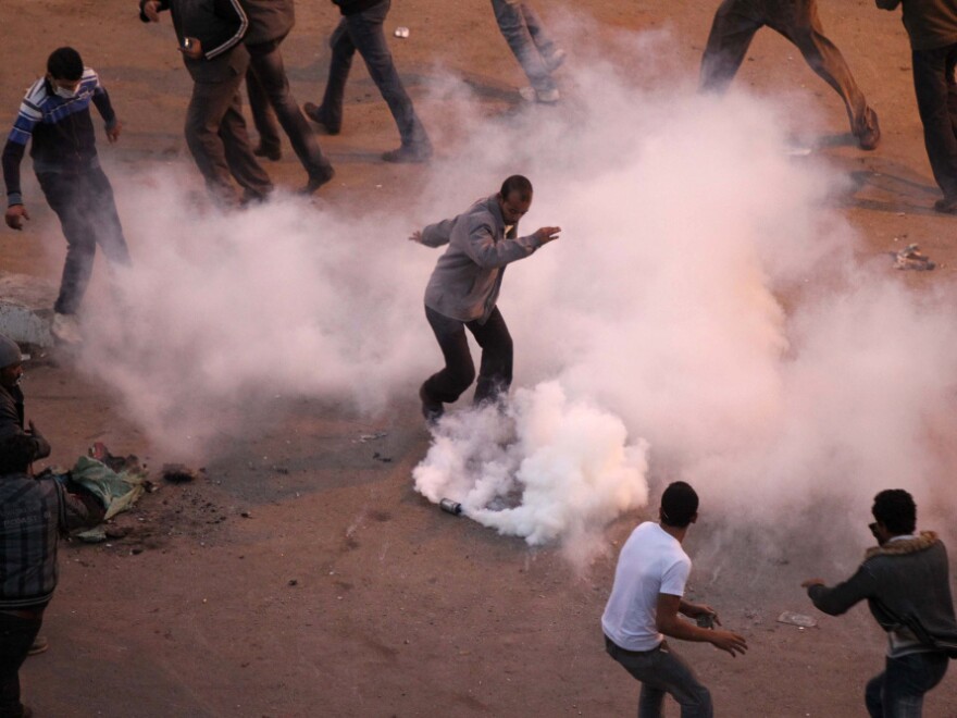During clashes in Suez on Jan. 27, Egyptian demonstrators demanding the ouster of President Hosni Mubarak try to remove a tear gas canister thrown by anti-riot police.
