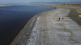 A couple walks along the receding edge of the waterline, showing record low water levels, at the Great Salt Lake, Sept. 6, 2022, near Salt Lake City.