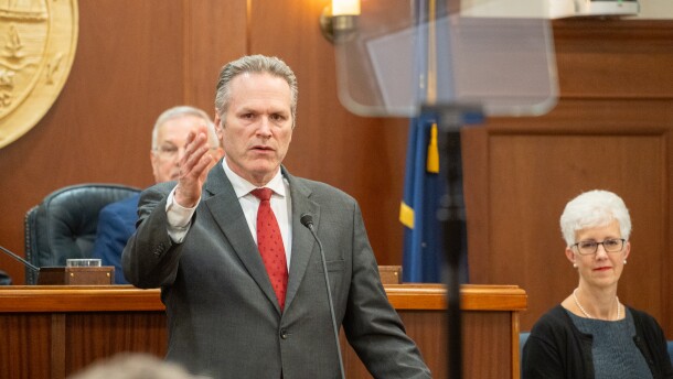 man gestures during speech in legislative chamber