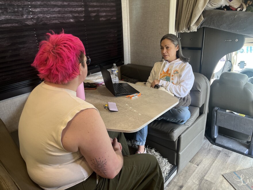 Astir Newman (left) sits next to Angelia Giampolo and her dog Niko, who rests on her lap.
