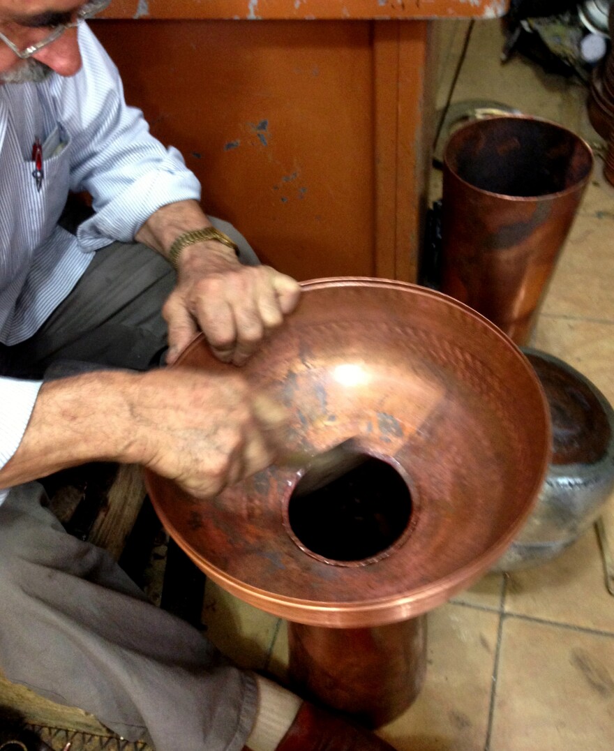 Mahmut Efeoglu works in his shop in the Trabzon copper market. The 70-year-old used to emphasize kitchenware — traditional copper pans, bowls and cups — but has branched out to making decorative copper minarets because the demand for copper cookware has diminished.