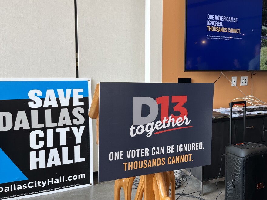 Signs for the D13 Together Coalition and Save Dallas City Hall during the D13 Together press conference August 4, 2026.