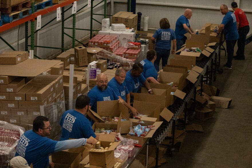 Volunteers with Food Lion pack goods into boxes at Golden Harvest Food Bank's volunteer center in Aiken. The group packed 460 boxes.