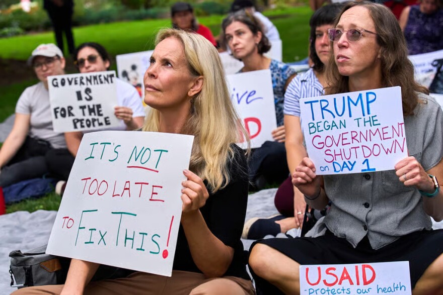 Layne Morrison, left, of Washington, and Courtney Creek, of Silver Spring, Md., who were let go from their jobs with the Education Department and a USAID-funded grant, respectively, hold signs about the looming government shutdown, Tuesday, Sept. 30, 2025, on Capitol Hill in Washington, during a rally with former federal employees.