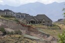 FILE - In this Aug. 5, 2014, photo, shows workers inspecting a large landslide that destroyed one home and caused the evacuation of dozens more, in North Salt Lake, Utah. Landslides threaten communities throughout Utah and they have crushed other homes in recent years, but no state agency in Utah formally tracks them and no protocols are in place to detect them ahead of time and prevent the kind of damage seen this week in North Salt Lake, where soggy 400-foot mountain slope tumbled into a Utah home. 