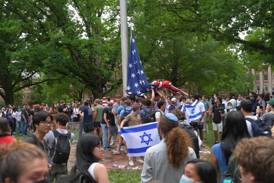 Students — mostly young men who belong to UNC-Chapel Hill fraternities — hold up the U.S. flag after it was removed by protestors and replaced with a Palestinian one on Tuesday, April 30, 2024.