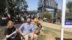 Visitors watch the skies ahead of the 2024 total solar eclipse at Riverfront Park in downtown Little Rock.