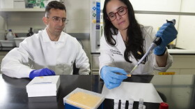 Emanuele Alves, Ph.D., (right) an assistant professor in the Department of Forensic Science, uses a pipette to demonstrate how her testing device would work, while Wagner Pacheco, Ph.D., (left) a postdoctoral fellow and researcher in her lab, looks on. (Tom Kojcsich, Enterprise Marketing and Communications)