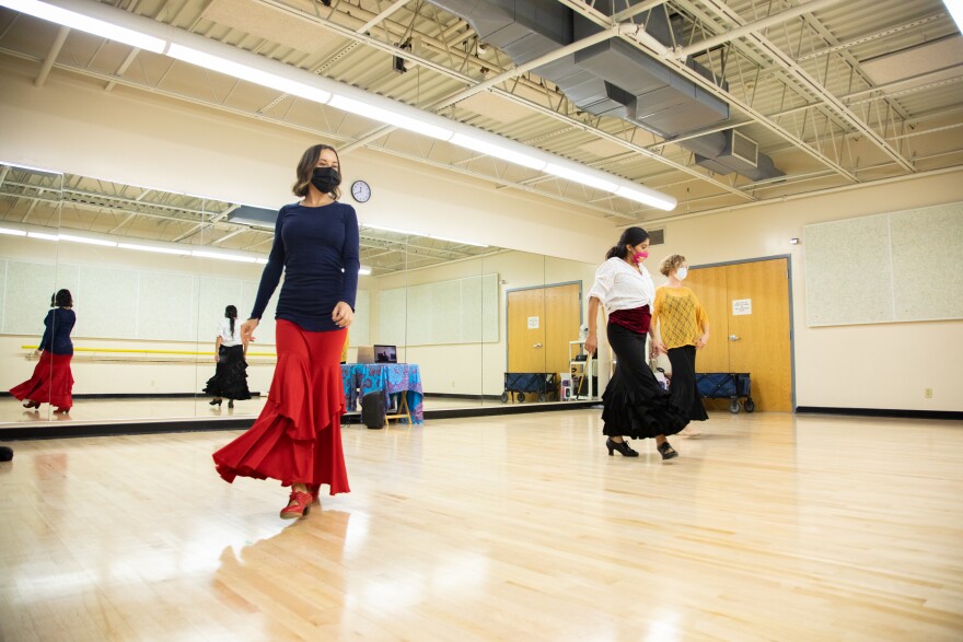 Three women dancing on a hardwood floor. 