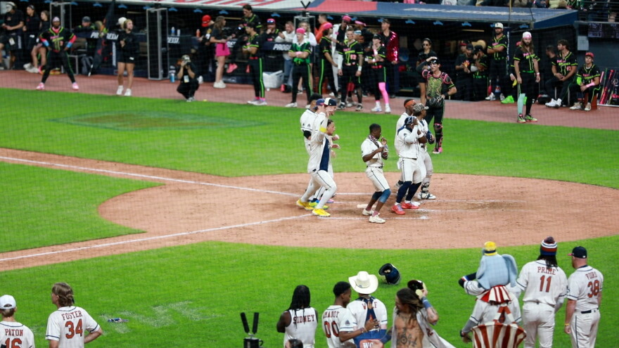 Baseball players dance around home plate during a Banana Ball game at Progressive Field