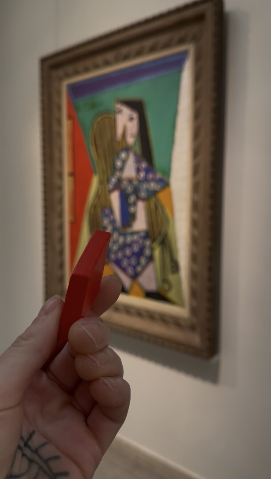 A red rhombus shaped tile is held in front of a Picasso painting at the Currier Museum of Art in Manchester.