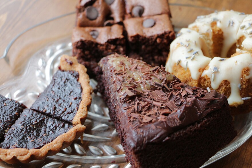 A selection of grain-free cakes and pastry samples offered by Primarily Inspired Eats. Counter clockwise, around the plate: red rasberry tart, chocolate-chocolate-chip brownie, vanilla lavender bundt and cake and chocolate caramel cake.