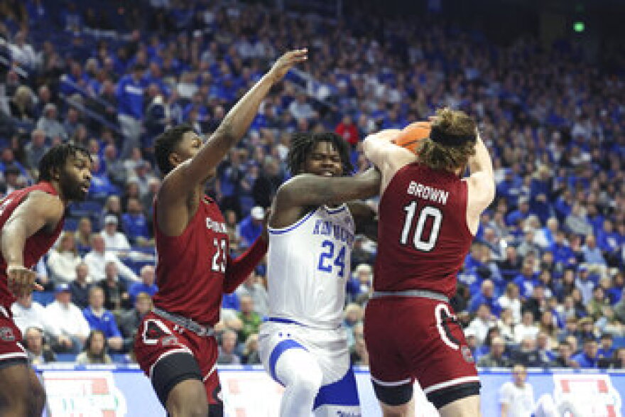 Kentucky's Chris Livingston (24) loses the ball between South Carolina's Gregory Jackson II (23) and Hayden Brown (10) during the first half of an NCAA college basketball game in Lexington, Ky., Tuesday, Jan. 10, 2023. (AP Photo/James Crisp)
